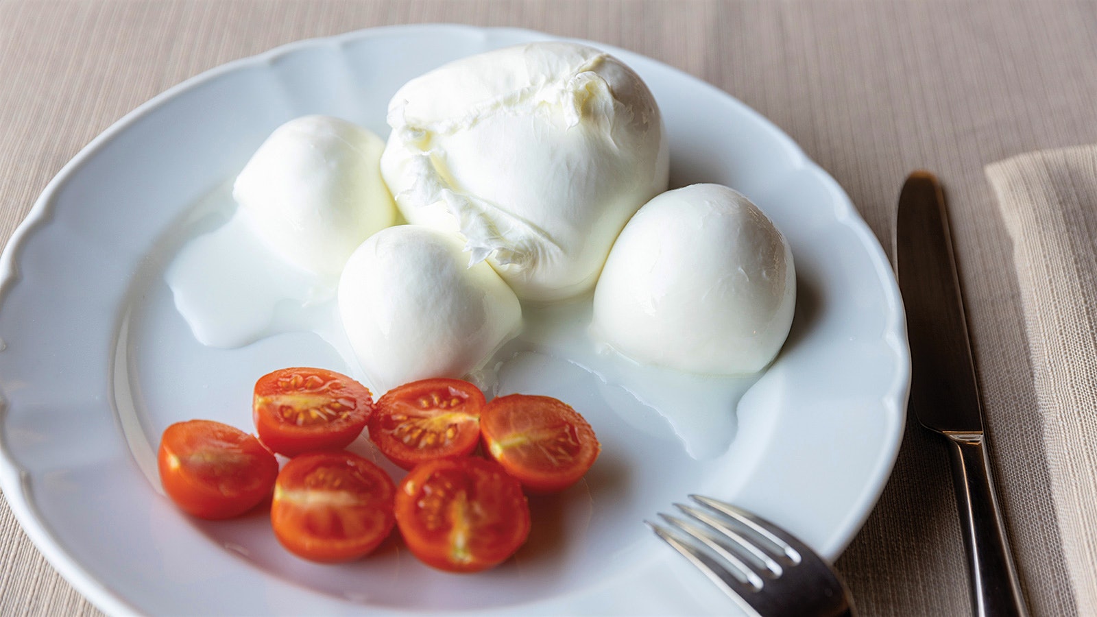 A plate of mozarella with sliced tomatoes